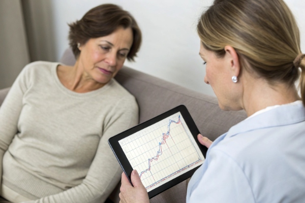 Doctor showing patient a rising results graph on a tablet (ID#2)