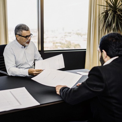 Reunión de negocios Dos hombres revisando documentos en un entorno de oficina (ID#5)