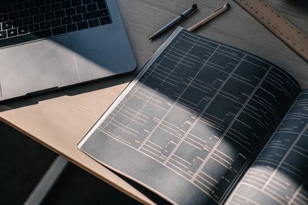 Arbeitsplatz mit Laptop und Bauplan auf dem Schreibtisch (ID#2)