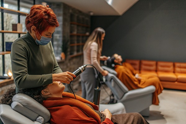 Person erhält Behandlung mit Handgerät in einem Salon (ID#4)