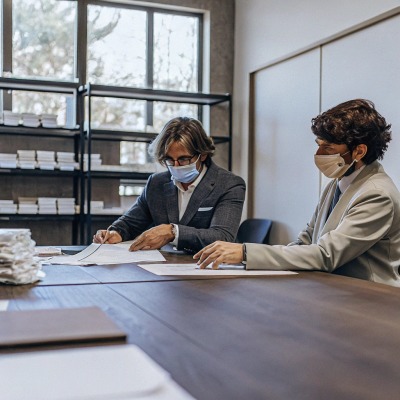 Zwei Personen besprechen Dokumente im Büro (ID#4)